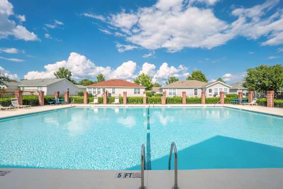 a swimming pool with blue water and houses in the background  at Huntington Village **, Warner Robins, GA, 31098