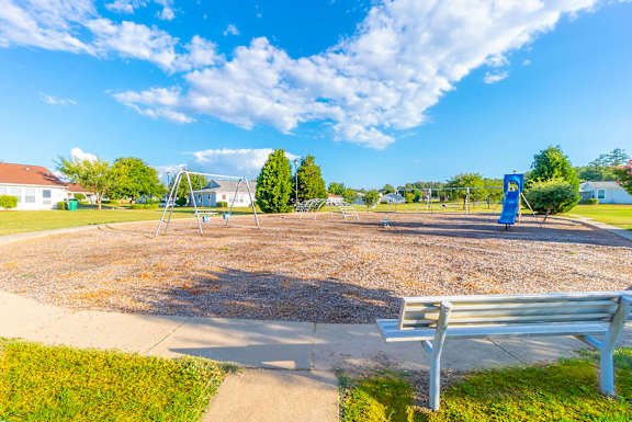 a park bench sitting in front of a playground  at Huntington Village **, Warner Robins