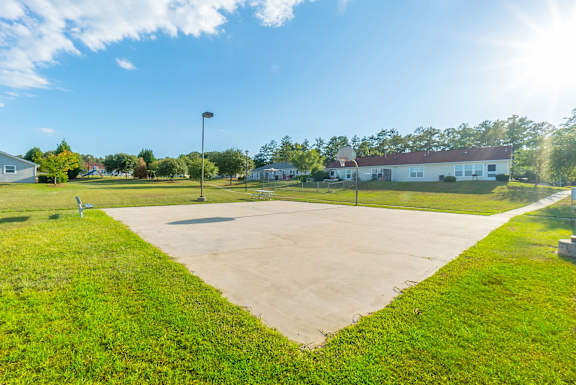 a basketball court in a park with a building in the background  at Huntington Village **, Warner Robins, GA