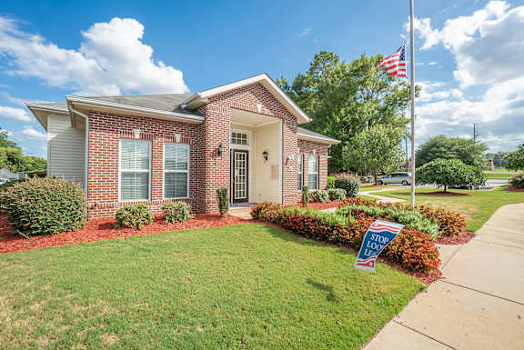 a small brick house with an flag on a pole in front of it  at Huntington Village **, Warner Robins, GA, 31098