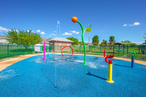 a water park with colorful water toys in a blue pool  at The Village at Cottonwood Springs, Texas