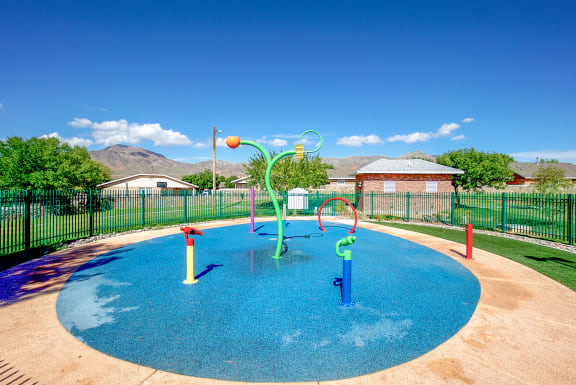 a childrens pool with water toys in a fenced in yard  at The Village at Cottonwood Springs, El Paso, 79934