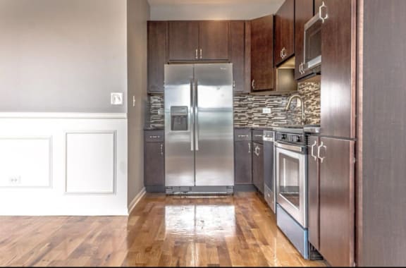 A kitchen with a stainless steel refrigerator and oven.