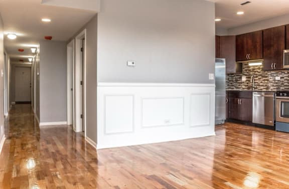 A kitchen with wooden floors and white walls.