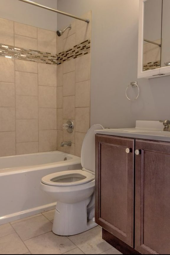 A white toilet sits next to a bathtub in a bathroom.