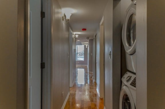 A long hallway with a washer and dryer on the right.