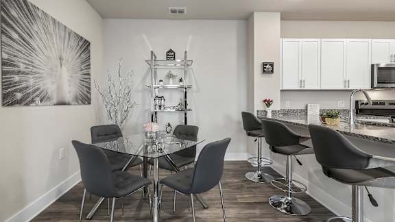 A modern dining room with a glass table and chairs.