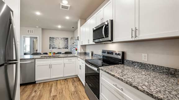 A modern kitchen with granite countertops and stainless steel appliances.