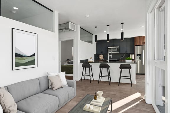 Model living room and kitchen with bar area at Post House South located in Post District Residences in downtown Salt Lake City, Utah