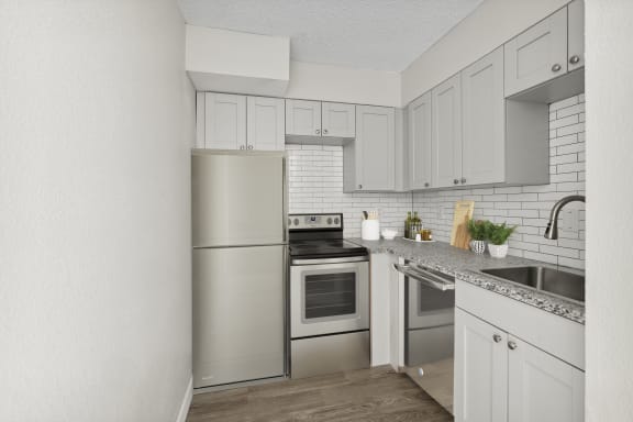a kitchen with white cabinets and stainless steel appliances