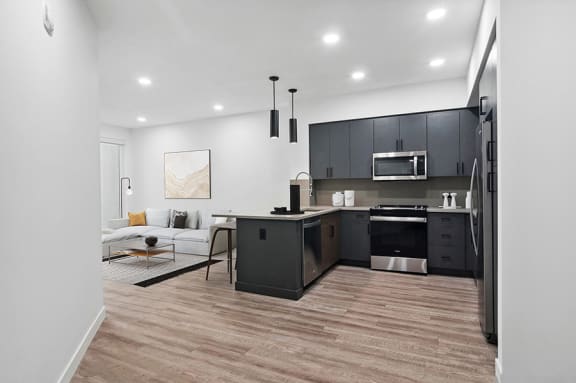 Model kitchen with dark designer cabinets at Post House North located in Post District Residences in downtown Salt Lake City, Utah