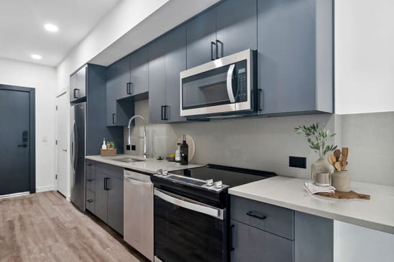Model kitchen with designer cabinets and stainless steel appliances at Post House North located in Post District Residences in downtown Salt Lake City, Utah