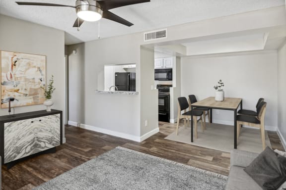 a living and dining area with a ceiling fan and hardwood floors