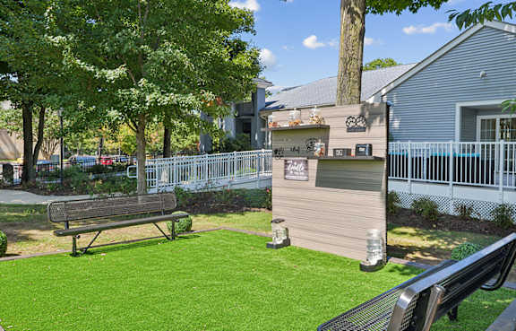 A park with a bench and a fence.