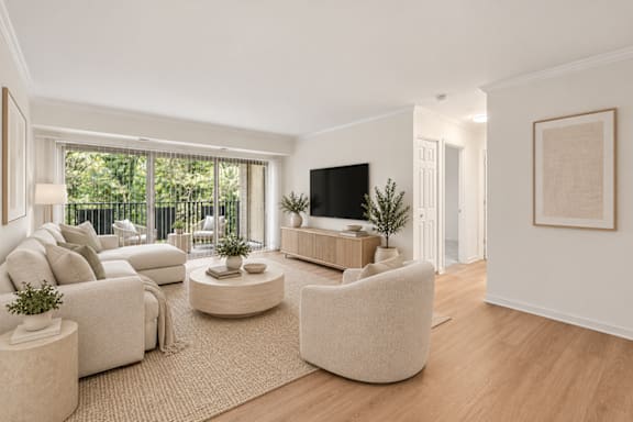A living room with a white couch, a white chair, a white coffee table, a white rug, a white wall, a white door, a white floor, a white ceiling, a white lamp, a white plant, a white so