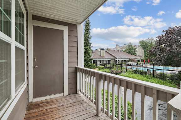 Private balcony overlooking community pool area at The Courts at Fair Oaks Apartments, Fairfax, VA