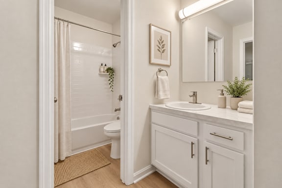 Bathroom vanity with white cabinetry and brushed nickel fixtures at The Courts at Fair Oaks Apartments, Fairfax, 22030