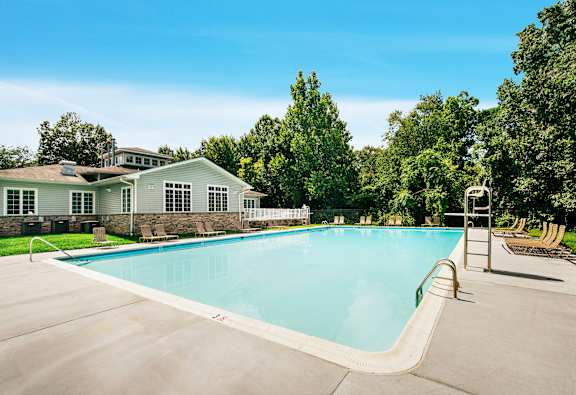 A large swimming pool in front of a house.