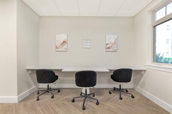 a conference room with a table and chairs and two paintings on the wall at Copper and Quarry Village, Pikesville, MD, 21209