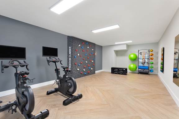 a gym with exercise machines and a rock climbing wall at Copper and Quarry Village, Pikesville, Maryland