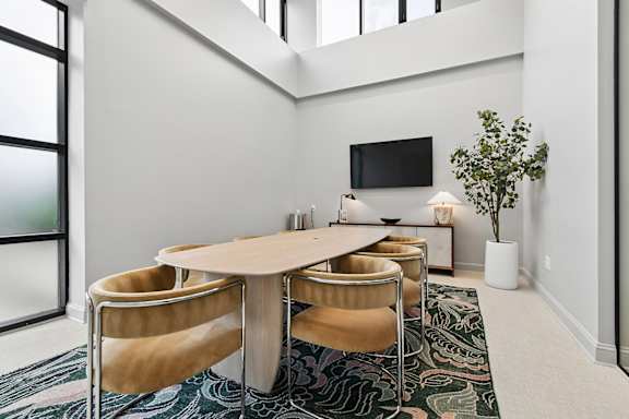A conference room with a long table and chairs.