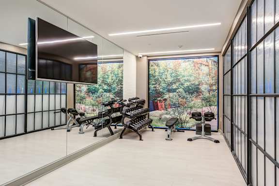 Gym with Row of Exercise Bikes at The Glover House Apartments, District of Columbia