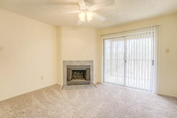 A living room with a fireplace and a ceiling fan at Pear Orchard, Ridgeland, MS