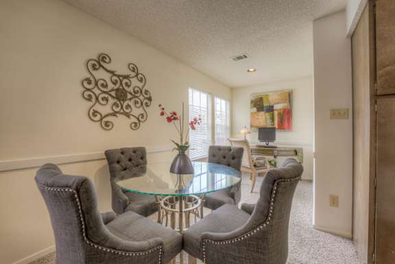 A living room with a glass table and grey chairs at Pear Orchard, Ridgeland
