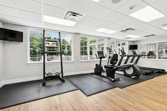 A gym with a treadmill, elliptical trainer and a stationary bike.