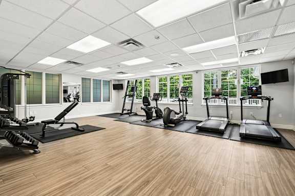 A gym with treadmills, elliptical machines, and other exercise equipment.
