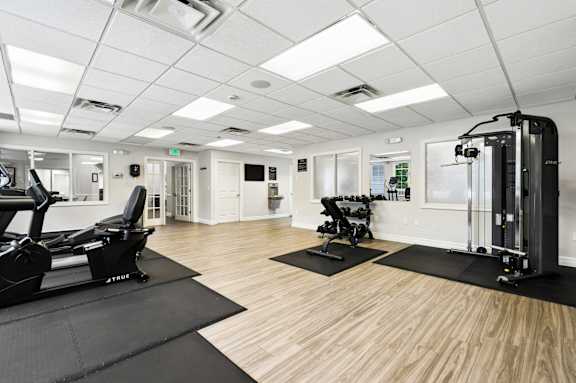 A gym with a treadmill, weights, and exercise equipment.