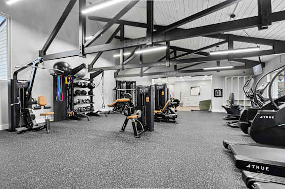 A gym with a variety of exercise equipment including treadmills, weights, and exercise machines.