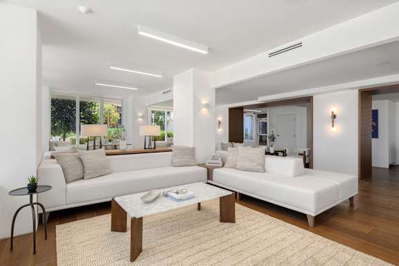 Open living room with modern white sofas at The Hamilton Apartments, Miami, 33137