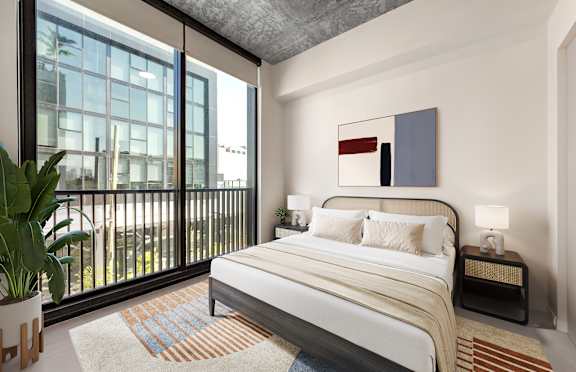 a bedroom with a large window and a bed with a striped comforter