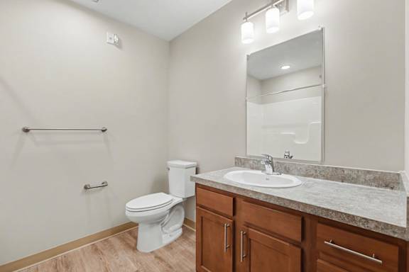 A bathroom with a toilet, sink, and mirror.