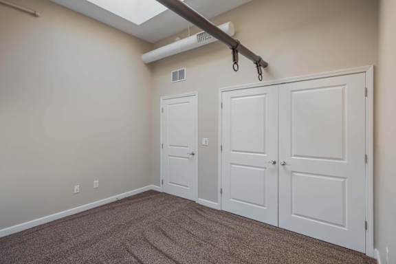 A room with a carpeted floor and a white door.