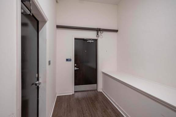 A hallway with a door at the end and a wall on the right.