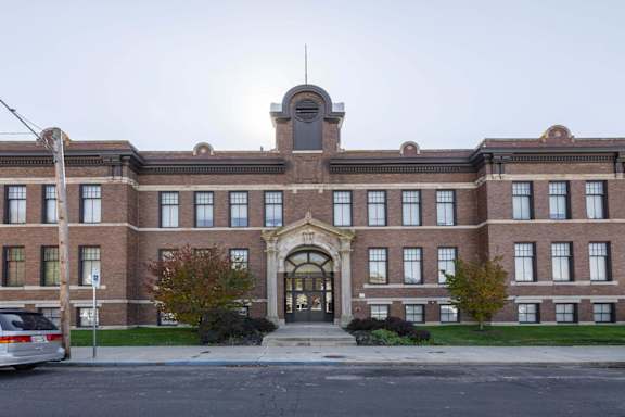 A large red brick building with a central arched entrance.