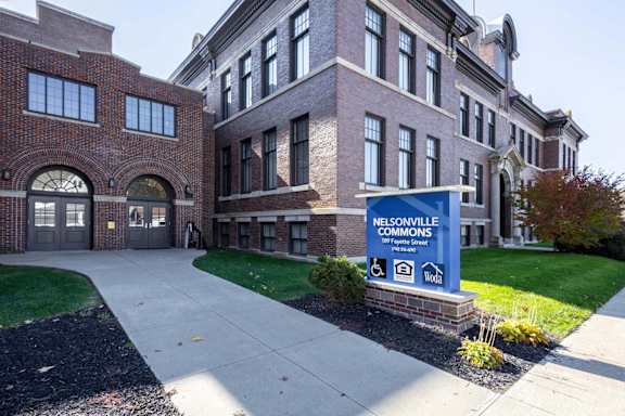Nelsonville Commons is a large brick building with a sign in front of it.