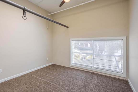 A room with a window covered by white blinds.