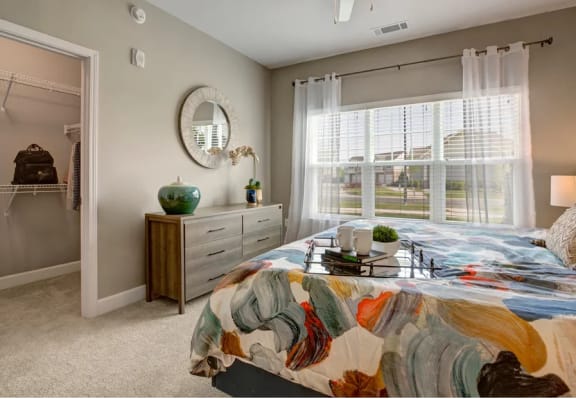Bedroom, queen size bed, carpet, large window with drapes at Ascent at Mallard Creek Apartment Homes, Charlotte, NC, 28262