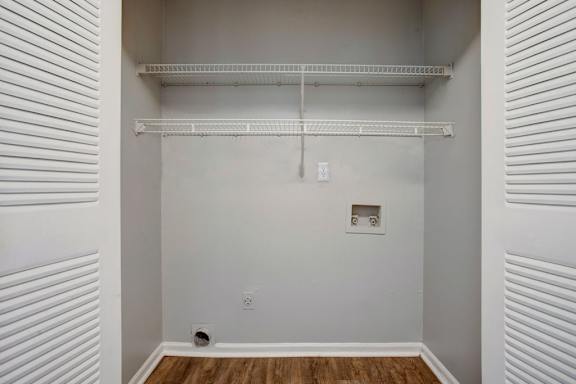 a bedroom with a white wall and a closet with a shelf