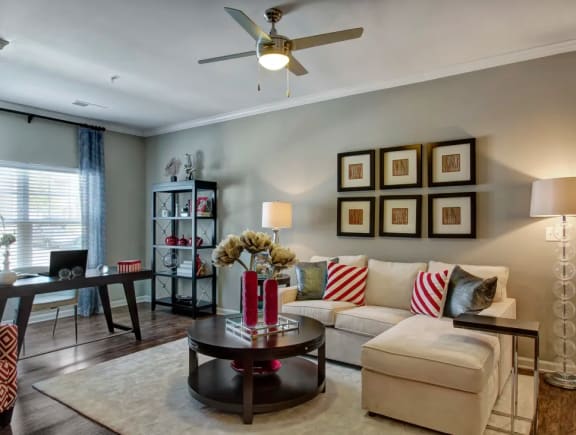 Living room, wood-like flooring, large couch and desk at Enclave at Bailes Ridge Apartment Homes, Indian Land, SC