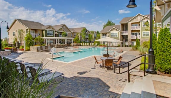 Sparkling swimming pool with lounge chairs at Enclave at Bailes Ridge Apartment Homes, Indiana Land, 29707