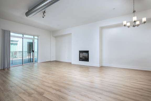 an empty living room with white walls and a fireplace