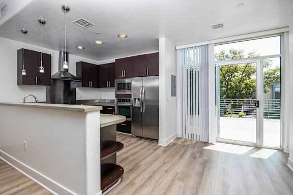 a kitchen with a stainless steel refrigerator and a door to a patio