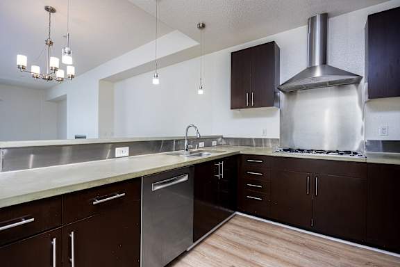 a large kitchen with stainless steel appliances and wood flooring