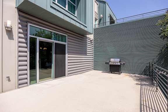 a patio with a grill outside of a building