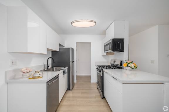 A kitchen with white cabinets and appliances.