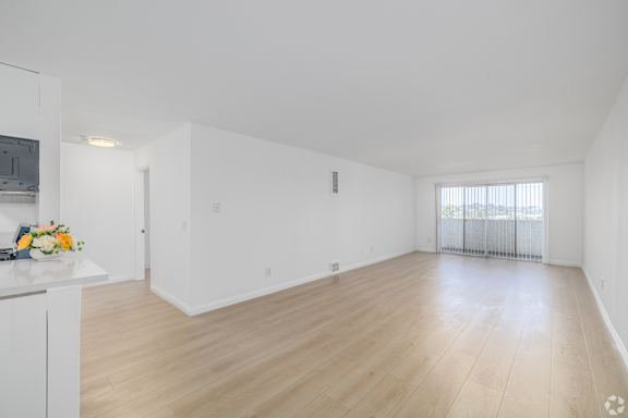A large empty room with wooden floors and white walls.